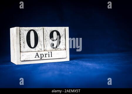 Am 9. April, 9. April, 9 Tag des Monats April - Rustikal weiss Kalender Blöcke auf dunkelblauem Hintergrund mit leeren Raum für Text Stockfoto