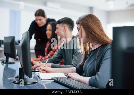 Jeder seine Arbeit tun. Gruppe von jungen Menschen in Freizeitkleidung im modernen Büro Stockfoto
