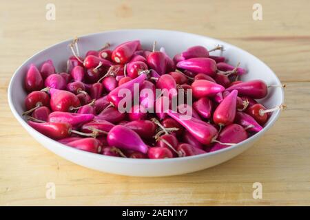 Frische tropische Pitiguey Fruchtgruppe in weißem Teller auf Holztisch. Stockfoto