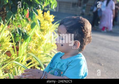 Cute Hut tragen baby boy vor einem wunderschönen tropischen Blume posieren. Portrait von einem gemischten Rennen baby boy Stockfoto