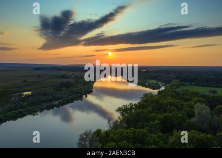 Sonnenaufgang oder Sonnenuntergang mit Wald und Fluss Stockfoto