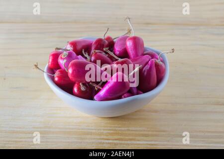 Frische Pitiguey Obstgruppe in weißer Schale auf Holztisch Stockfoto