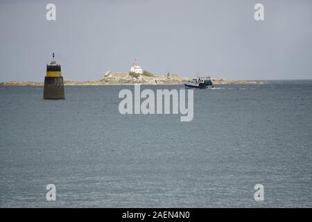 Sonnenstrahlen auf den Leuchtturm auf der Insel und Fischerboot an der Küste der Bretagne, Frankreich Stockfoto