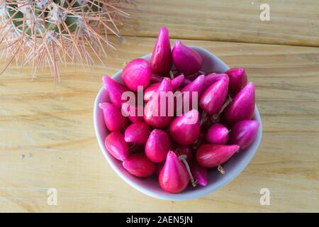 Pitiguey Obstgruppe in weißer Schale auf Holztisch mit Kaktus. Von oben nach unten Stockfoto