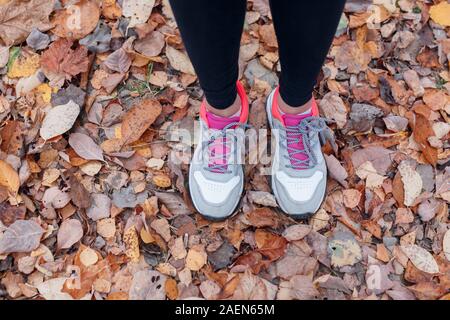 In der Nähe der Füße ein Läufer läuft im Herbst Blätter in Park Stockfoto