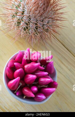 Pitiguey Obstgruppe in weißer Schale auf Holztisch mit Kaktus. Vertikal Stockfoto