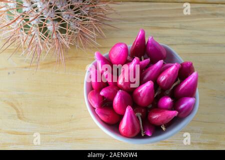 Pitiguey Obstgruppe in weißer Schale auf Holztisch mit Kaktus. Von oben nach unten Stockfoto