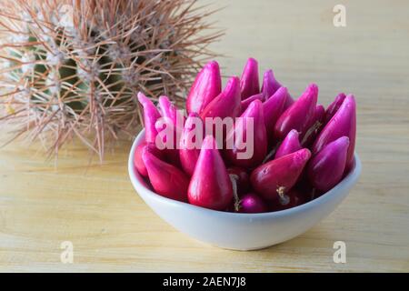 Pitiguey tropische Fruchtgruppe in weißer Schale auf Holztisch mit Kaktus. Stockfoto