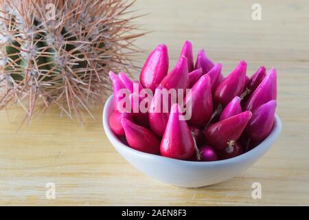 Pitiguey Obstgruppe in weißer Schale auf Holztisch mit Kaktus. Stockfoto