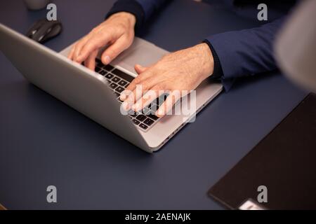 Nahaufnahme von alten Menschen die Hände auf neuen Laptop. Stockfoto