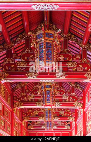 Erstaunlich, verzierte Decken in rot Holz- Flur in Lila der Verbotenen Stadt (Imperial Zitadelle) in Hue, Vietnam Stockfoto