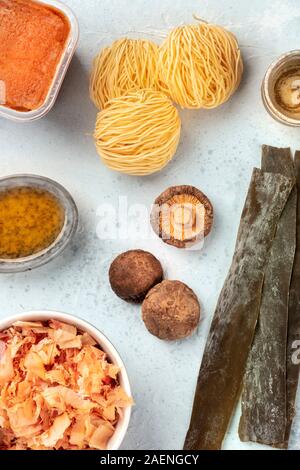 Ramen Zutaten. Getrocknete meer Gemüse Kelp, Soba-Nudeln, Miso einfügen, Thunfisch Flocken, Shiitake-Pilze, mirin, Sake Soße in eine Tasse, Overhead shot Stockfoto