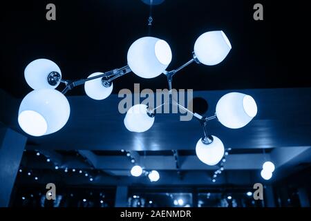 Eine wunderschöne, moderne Kronleuchter in Blau hängt an der Decke. Die Hauptfarbe des Jahres 2020. Stockfoto