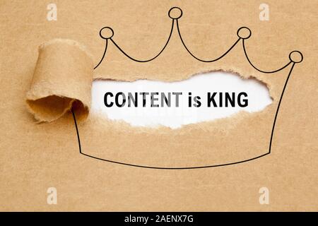 Text Inhalt ist König hinter zerrissen braunes Papier in der Krone Zeichnung erscheinen. Konzept über die Bedeutung von Content im Internet Marketing. Stockfoto