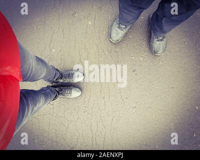 Zwei Menschen, ein Mann und ein Mädchen auf der Straße sind in Leder Stiefel. Blick von oben. Stockfoto