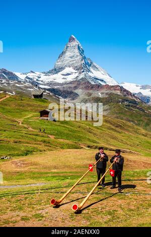 ZERMATT, SCHWEIZ - 16. JULI 2019: Swiss alphorn Gebläse sind für die Wiedergabe von Musik in der Nähe von Das Matterhorn in den Alpen zwischen der Schweiz ein Stockfoto