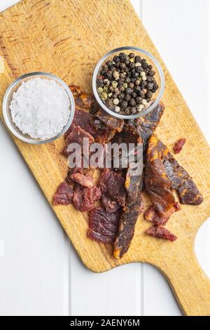 Beef Jerky Stücke mit Salz und Pfeffer. Getrocknetes Rindfleisch. Ansicht von oben. Stockfoto