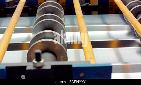 Blech schneiden/forming Maschine für die Herstellung von Stahlrohren, Rohren und Profilen aus Metall im Werk. Konzept für metallarbeiten Produktion und b Stockfoto