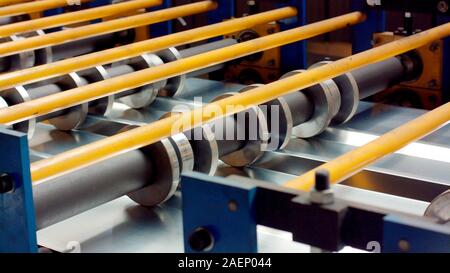 Blech schneiden/forming Maschine für die Herstellung von Stahlrohren, Rohren und Profilen aus Metall im Werk. Konzept für metallarbeiten Produktion und b Stockfoto
