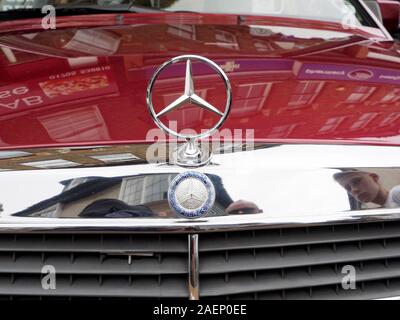 Mercedes Benz tri-Star Logo auf der Motorhaube eines Oldtimers aus der Nähe. Stockfoto