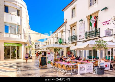 Restaurant im Freien in der Straße mit traditionellen portugiesischen Kopfsteinpflastersteinen gepflastert, calcada, das Einkaufszentrum Faro, Ostalgarve Portugal. Stockfoto