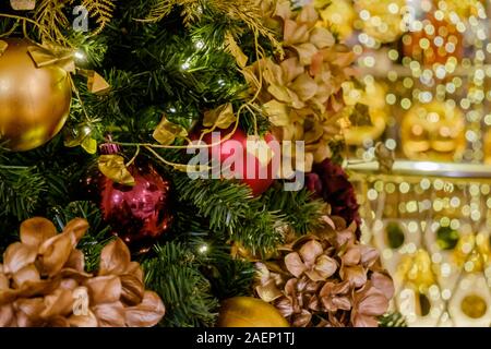 Nahaufnahme der Weihnachtsbaum mit farbenfrohen roten Purpur und Gold Flitter und festliche Dekorationen und unscharfer Hintergrund. Stockfoto