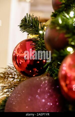 Nahaufnahme der Weihnachtsbaum mit farbenfrohen roten Purpur und Gold Flitter und Dekorationen. Stockfoto