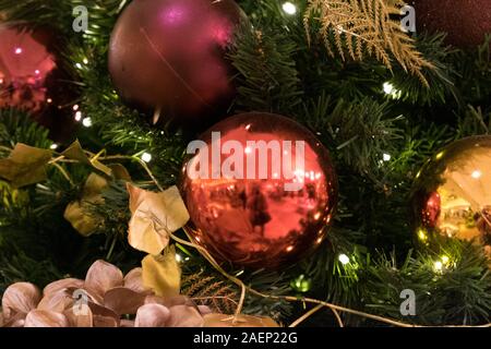 Nahaufnahme der Weihnachtsbaum mit farbenfrohen roten Purpur und Gold Flitter und Dekorationen. Stockfoto