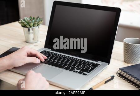Laptop Bildschirm mockup. Mann bei der Arbeit mit einem schwarzen, leeren Bildschirm Computer auf einem Schreibtisch, Büro Background, kopieren Raum Stockfoto