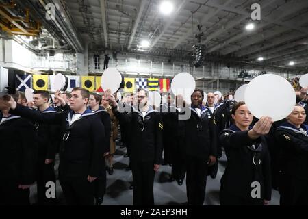 Mitgliedern der Besatzung geben drei Beifall für die königliche Familie während der Aussendung der Royal Navy Flugzeugträger HMS Prince of Wales, in Portsmouth Naval Base. Stockfoto