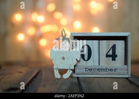 Cube Holz- Kalender mit Datum am 4. Dezember mit Angel über bokeh Hintergrund. Adventskalender, Weihnachten Hintergrund, Kopieren Raum Stockfoto