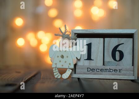 Cube Holz- Kalender mit Datum vom 16. Dezember mit Angel über bokeh Hintergrund. Adventskalender, Weihnachten Hintergrund, Kopieren Raum Stockfoto