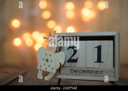 Cube Holz- Kalender mit Datum des 21. Dezember mit Angel über bokeh Hintergrund. Adventskalender, Weihnachten Hintergrund, Kopieren Raum Stockfoto