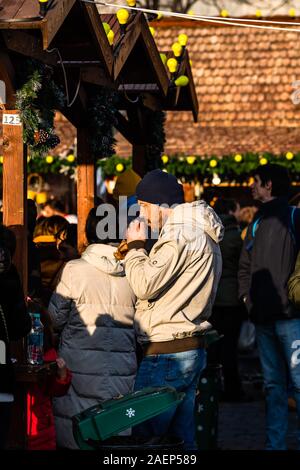 Menschen ein Mittagessen mit rumänischen traditionellen Essen in Bukarest Weihnachtsmarkt. Bukarest, Rumänien, 2019. Stockfoto