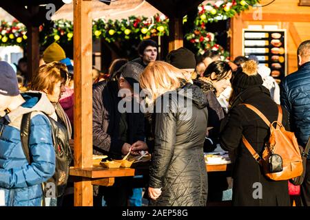 Menschen ein Mittagessen mit rumänischen traditionellen Essen in Bukarest Weihnachtsmarkt. Bukarest, Rumänien, 2019. Stockfoto