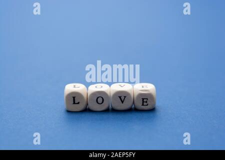Liebe ist Liebe Nachricht auf Holzklötze auf blauem Hintergrund geschrieben. Stockfoto