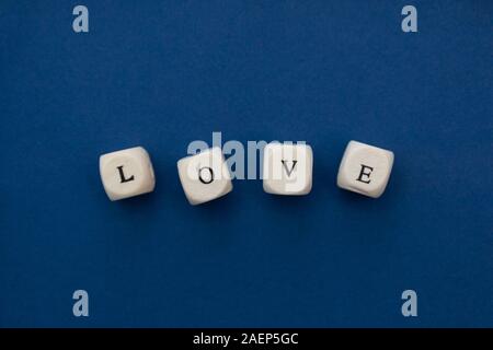 Liebe ist Liebe Nachricht auf Holzklötze auf blauem Hintergrund geschrieben. Stockfoto