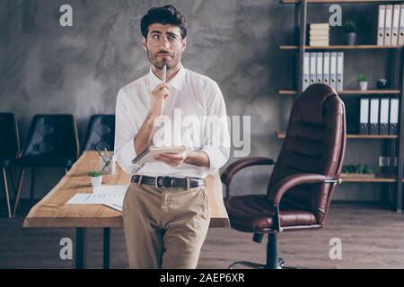 Portrait des Buendnisses indischen Kragen halten Copybook wollen Plan seiner täglichen Arbeit Aufgaben in der Nähe der Tabelle stehen, tragen weiße Hemd im Loft Enterprise Stockfoto