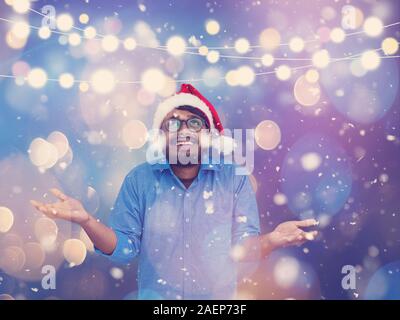 Inder, die traditionelle Santa Claus Hut auf dem Schwarzen Brett Hintergrund studio Dunkelhäutige weihnachten santa Neues Jahr Partei Stockfoto