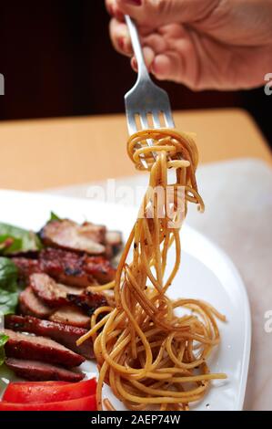 In Scheiben geschnitten BBQ Schweinebauch mit Nudeln und Salat Stockfoto