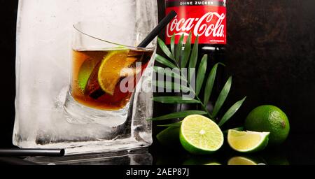 Coca Cola in ein Glas mit Flasche Ice Cube - Eis schmelzen - Schwarzer Hintergrund Stockfoto