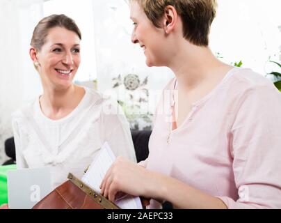 Zwei glückliche Frau sitzen zusammen Stockfoto