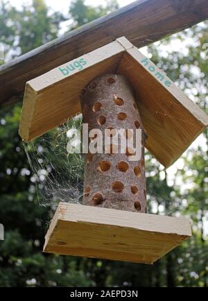 Ein Insekt Hotel oder Bug Haus hängen von einem Rahmen in einem Garten Stockfoto