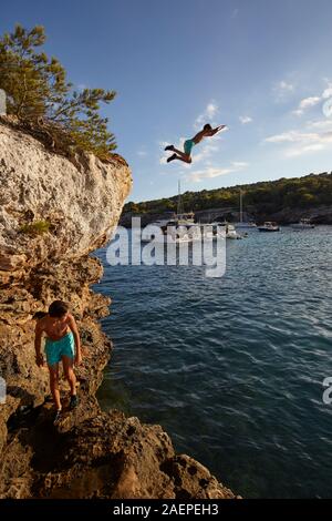 Junge Tauchen vom Felsen in Cala en Turqueta, Menorca, Balearen, Spanien Stockfoto