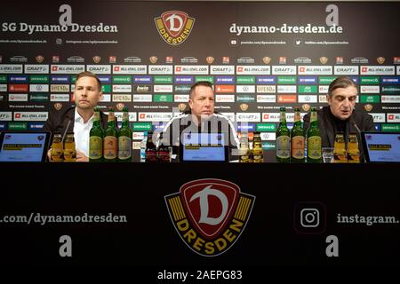 Dresden, Deutschland. 10 Dez, 2019. 10 Dezember 2019, Sachsen, Dresden: Heinrich Buschmann (L-R), Press Officer Dynamo Dresden, Markus Kauczinski, Coach Dynamo Dresden, und Ralf Minge, Geschäftsführer Sport SG Dynamo Dresden, sitzen nebeneinander, während einer Pressekonferenz. Kauczinski hat einen Vertrag bis zum 30. Juni 2021 mit Dynamo Dresden, die zweite Liga Rücklicht unterzeichnet. Quelle: dpa Picture alliance/Alamy leben Nachrichten Stockfoto