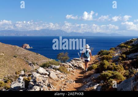 Walker auf Fußweg von Mikro Horio nach Lethra Beach, Tilos, Dodekanes Inseln, Südägäis, Griechenland. Stockfoto