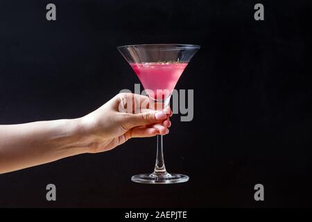 Weibliche Hand, die eine elegante Glas mit Cranberry alkoholfreien Cocktail Stockfoto
