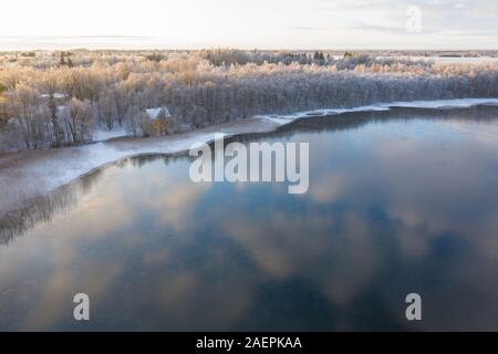 Antenne drone Blick auf den See, Küste starten im Winter sonnenaufgang Licht einzufrieren. Tartu, Estland. Stockfoto