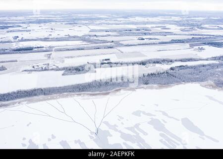 Antenne drone Ansicht eines teilweise zugefrorenen See mit Ungefroren Patches und Eis Risse an einem Wintermorgen. Tartu, Estland. Stockfoto