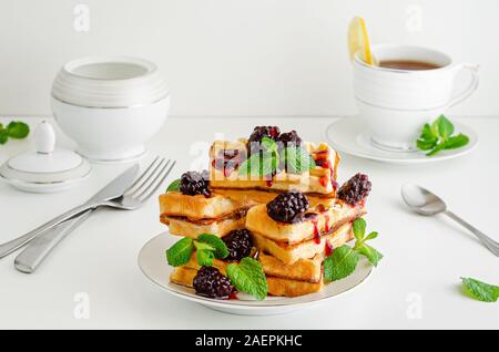 Stapel von Wiener Waffeln mit Blackberry jam und Minze auf weißem Hintergrund. Leckeres Frühstück. Stockfoto